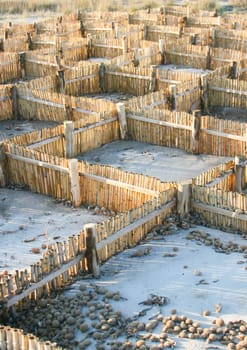 Barrier for sand. Useful against shoreline erosion