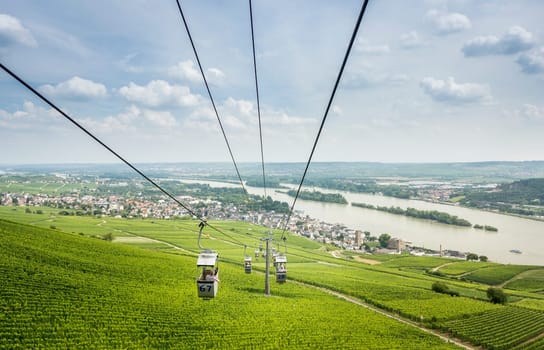 View of the river Rhine and Rudesheim with cable cars in the foreground passing over vineyards