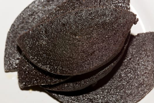 Swedish Blood Pudding on White Plate glisseing of butter.