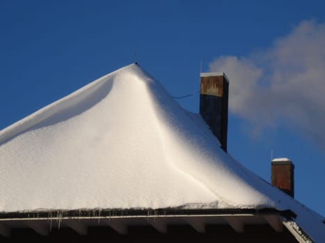 Smoking fireplace on a deep snow-covered roof - heating costs are rising again these days