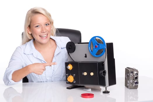 Blonde woman points to an old movie projector