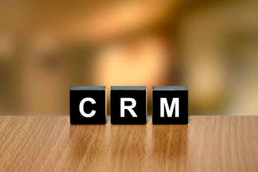 CRM or Customer relationship management on black block with blurred background