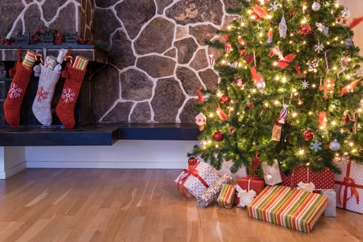 Stockings hanging on a fireplace next to a christmas tree on christmas morning