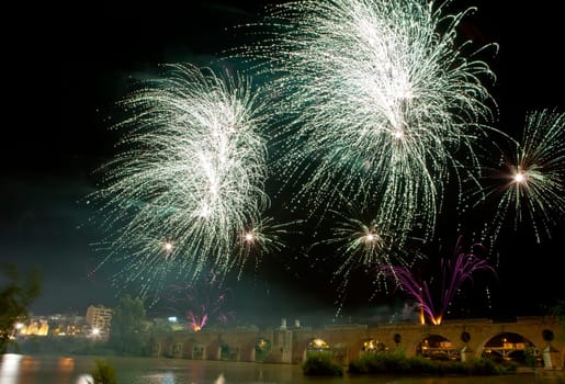Colorful fireworks shot from Puente de Palmas bridge at Badajoz, Spain, during the San Juan festivity night
