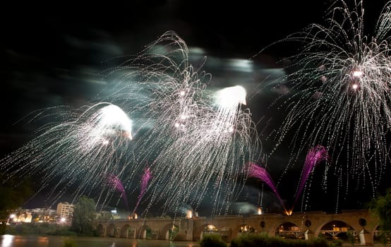 Colorful fireworks shot from Puente de Palmas bridge at Badajoz, Spain, during the San Juan festivity night