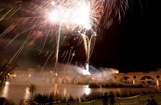 Colorful fireworks shot from Puente de Palmas bridge at Badajoz, Spain, during the San Juan festivity night