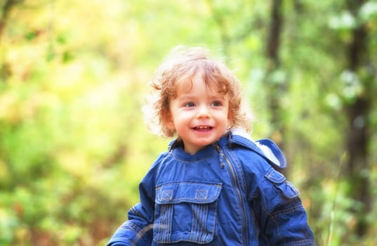 The portrait of a 1 and a half year old baby boy enjoying the outdoors in autumn.