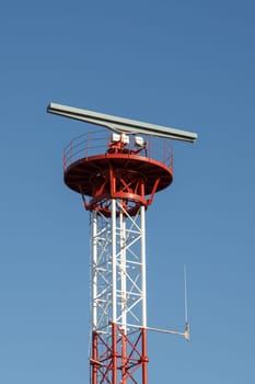 Tower with radar and antena against blue sky