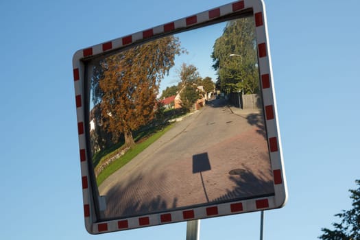 A convex mirror street sign on a road