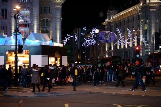 London,United Kingdom – November 29,2014: A crowd of tourists and pedestrians stand and cross a festively decorated intersection of Piccadilly Circus on November 29,2014 in London.