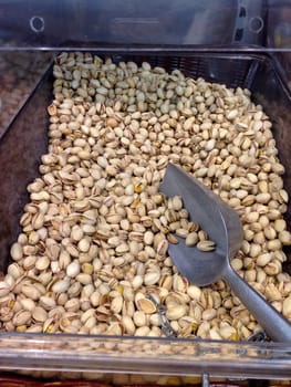 Box with different dry fruits on market with shovel for serve yourself