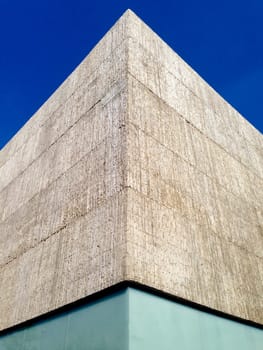 Abstract crop of concrete and glass modern building over blue sky
