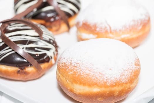 Chocolate and powdered sugar frosting donuts close up