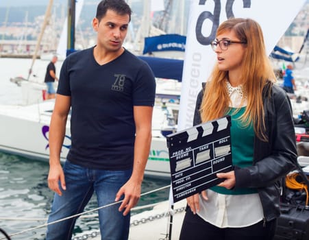 TRIESTE, ITALY - OCTOBER, 12: Girl holding clapperboard during the production of short film on October 12, 2014