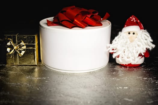 Christmas Santa Claus or Father Frost with gold and white gift boxes or presents on silver or metal grunge surface