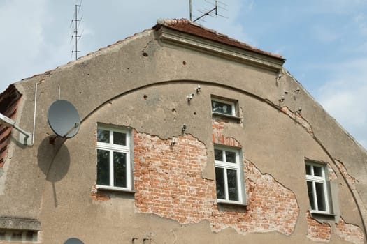 Facade of an old house with crumbling plaster