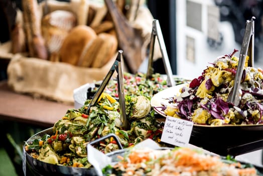 Salads in individual containers displayed on a buffet