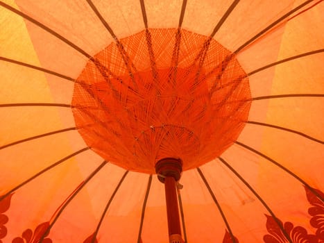 Interior of orange traditional Thai umbrella, craft against the sunlight