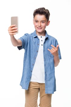 Young boy posing and taking a selfie against a white background.