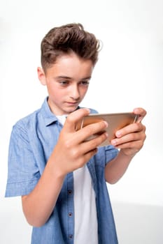 Portrait of a young boy taking a selfie against a white background.