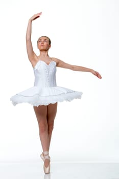 Young ballet dancer performing against a white background.