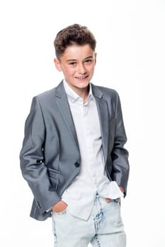 Happy young teenage boy dressed smartly on a white background. He is looking at the camera and smiling.