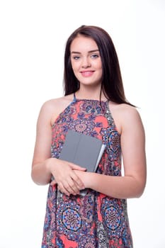 Portrait of a beautiful young woman holding a digital tablet against a white background. She is looking at the camera and smiling.