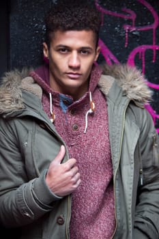 Portrait of an attractive, young, mixed-race man against an urban background in the city