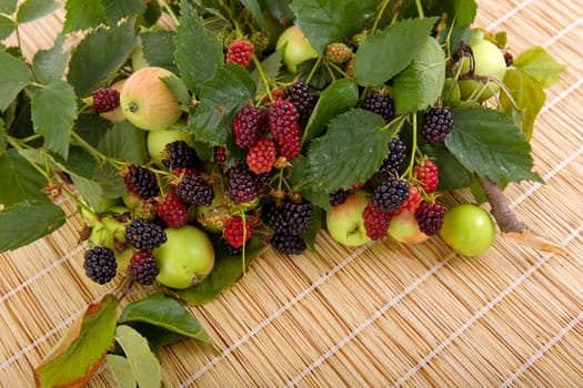apples and raspberries on a wooden table