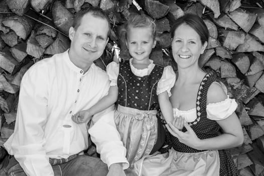 Family in costume poses on the farm in front of a pile of wood