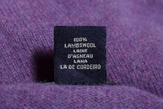 A black tag with white text on purple cloth