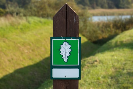 A green sign with a white leaf on it