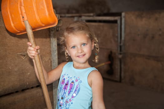 little girl playing on the farm in the cowshed
