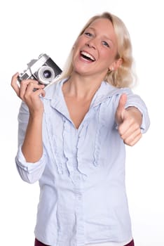Young woman holds an analog camera and shows up thumbs up