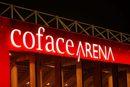 Mainz,Germany – March 07,2015: The facade of the Co Face Arena of the football club 1. FSV Mainz 05 with white illuminated advertising and red lighting at night on March 7,2015 in Mainz.