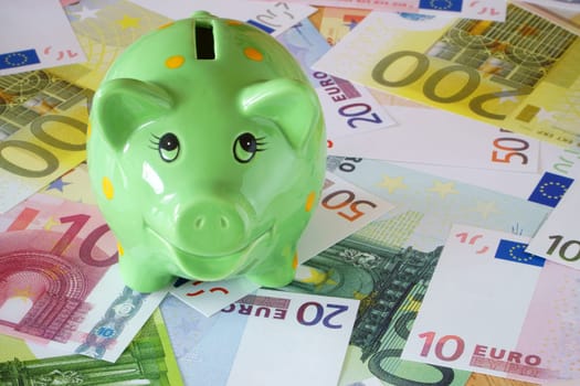 Green piggy bank and euro banknotes on finance