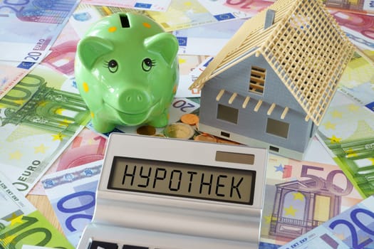 The word mortgage on display from calculator and piggy bank