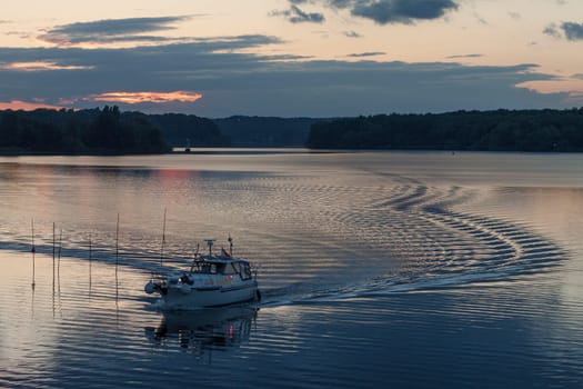 Motorboat with crooked wave track on the Havel