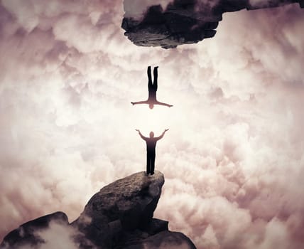 two people silhouettes communicate on different mountain peaks. Falling down in another reality. Freedom and risk concept.