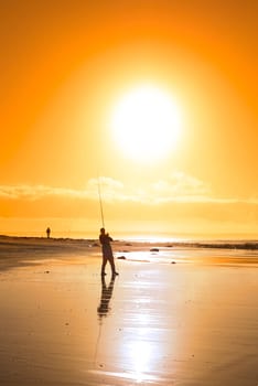 lone fisherman fishing on the beach in Ballybunion county Kerry Ireland