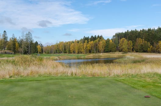 autumn at the golfcourse water and grass and a beutiful sky