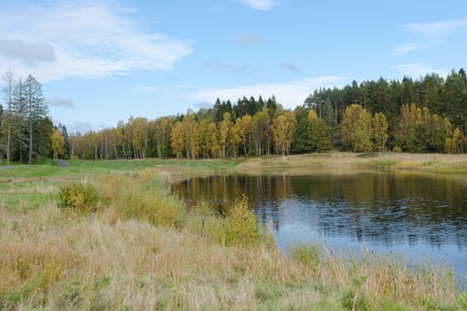 autumn at the golfcourse water and grass and a beutiful sky