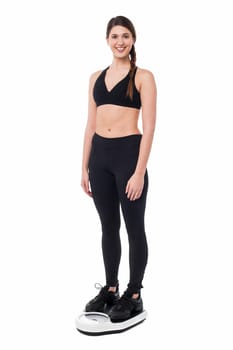 Young fit woman measuring her weight