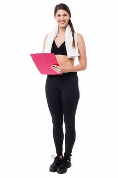 Young fit trainer holding a clipboard