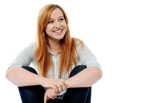 Young cheerful woman sitting on floor