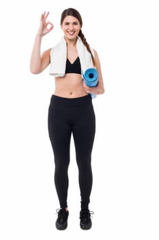 Fit woman holding exercise mat