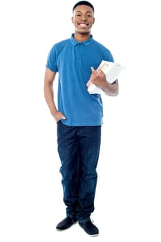 Smiling student posing with books in hand