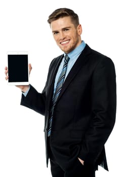 Smiling businessman displaying tablet device