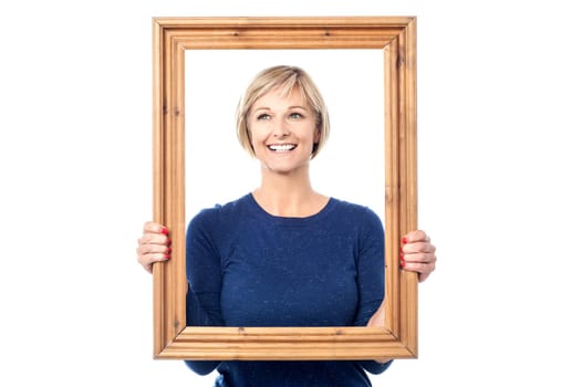 Lady looking through wooden frame