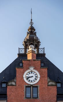 The Town House Clock and Steeple in Umeå, Sweden with a clear blue sky behind it.